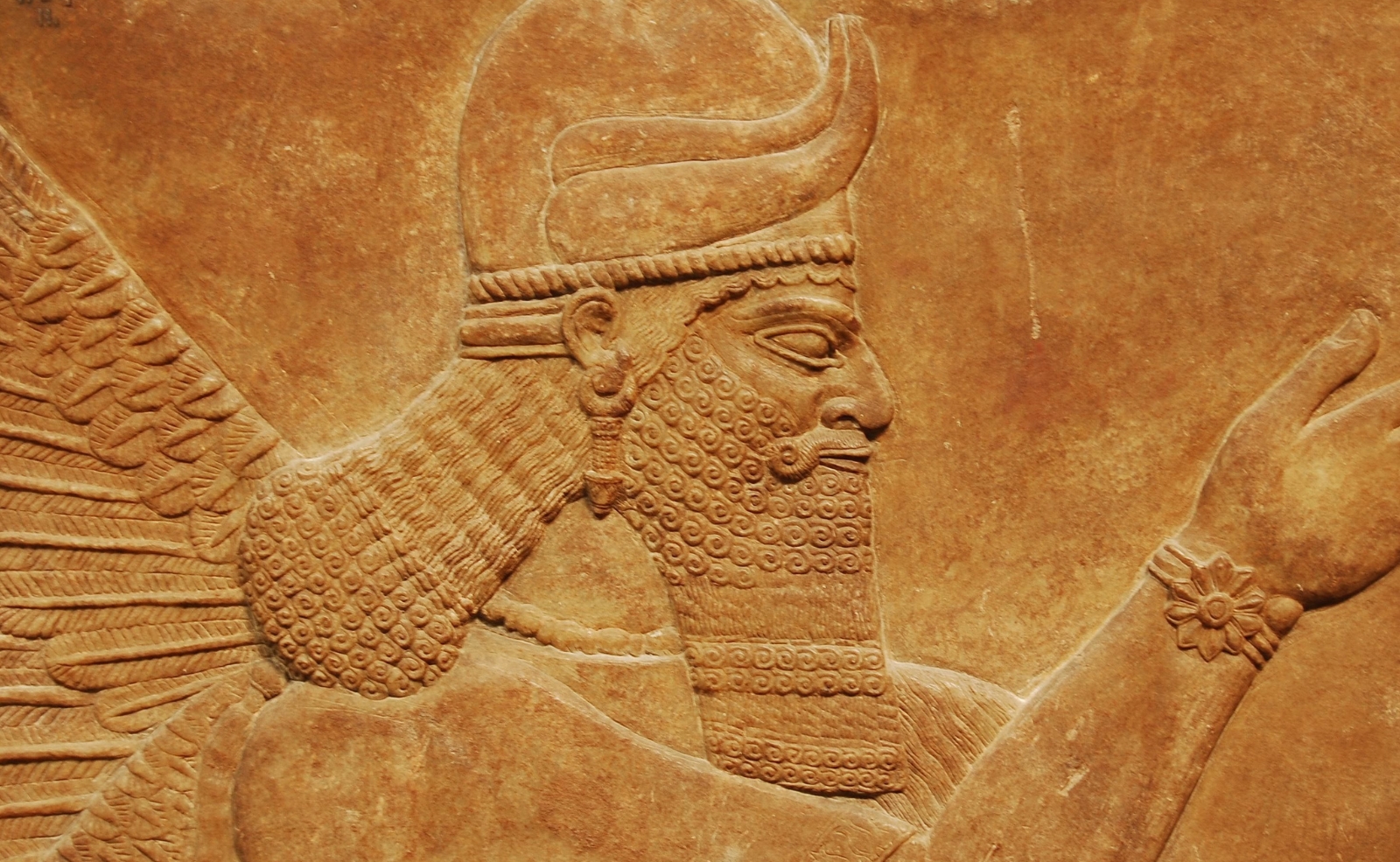 A carved stone relief of an ancient Mesopotamian winged protective spirit or genius.
